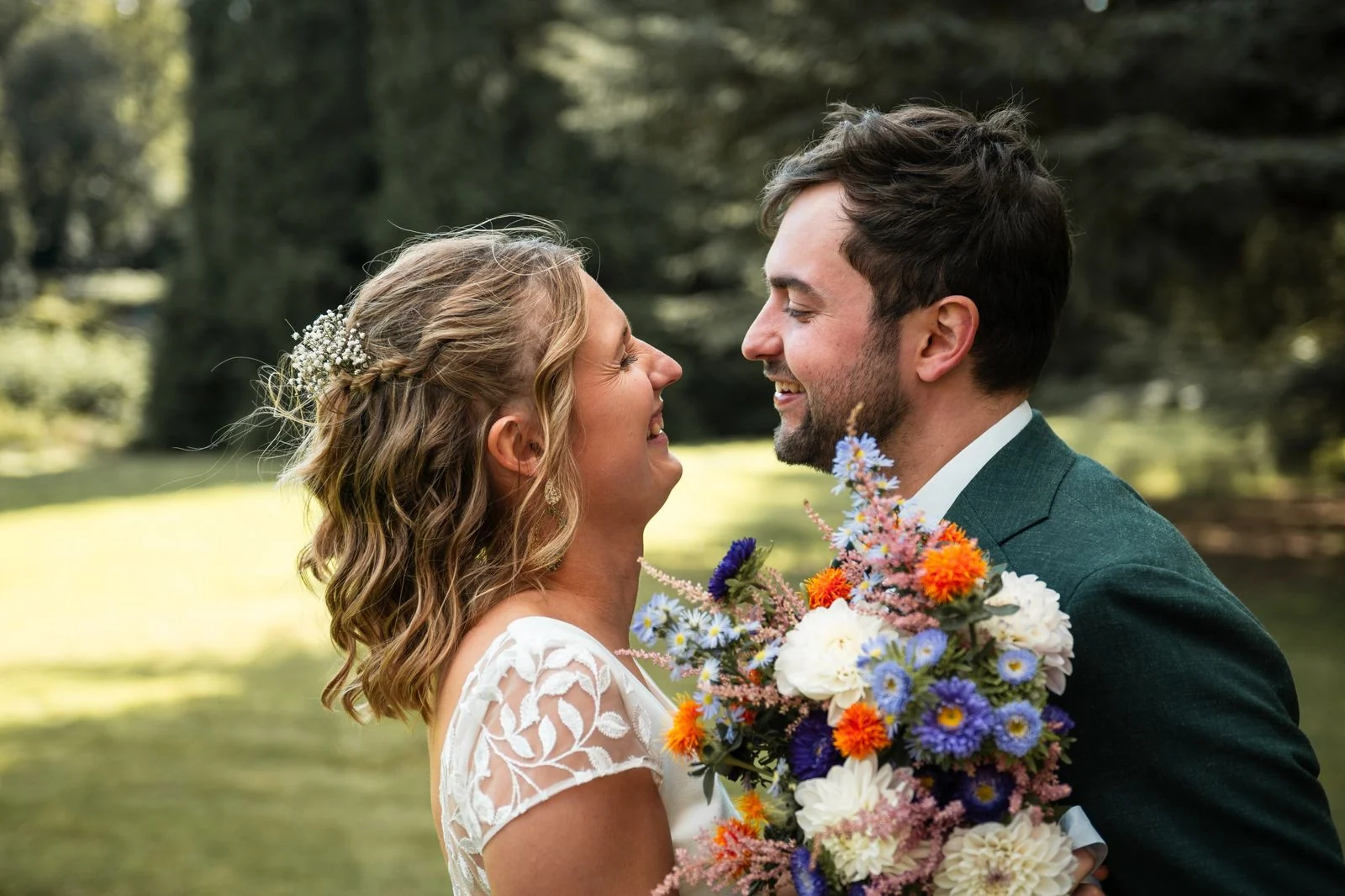 Bruidspaar kijkt elkaar aan met bloemen